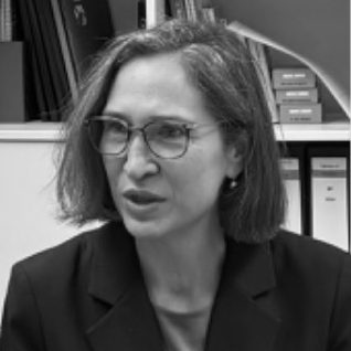 Porträt von Petra mit Brille und kurzen Haaren, im Gespräch mit einem/einer Klientin.